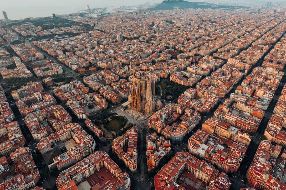 Aerial view of Barcelona with the Sagrada Família rising above red-roofed city blocks
