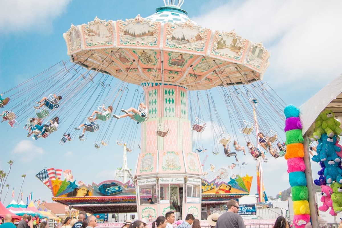 A colorful carnival swing ride against a bright blue sky